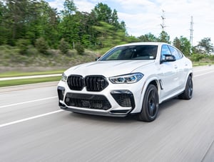 White BMW driving down a highway
