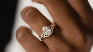 Classic, elegant engagement ring with a gold band and oval center diamond.