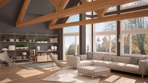 A beautiful luxury home living room with a cream sofa, large open windows, exposed wood beams and plants on a shelf
